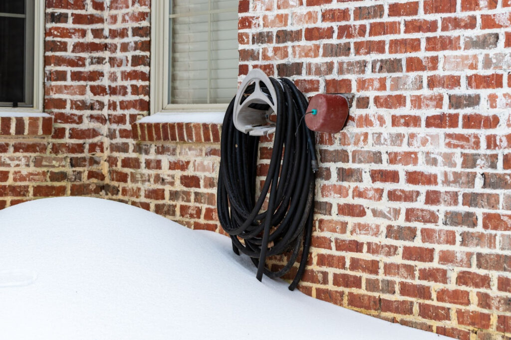 Snow-covered outdoor hose connection at a home prepared by A&N Plumbing to prevent frozen pipes in Wenatchee, WA. 
