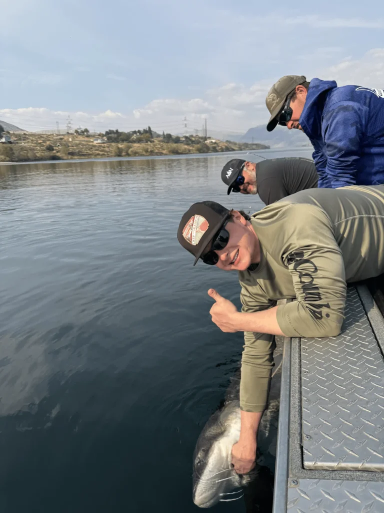 Jaydze reeling in the eight foot sturgeon during the A&N Plumbing summer trip