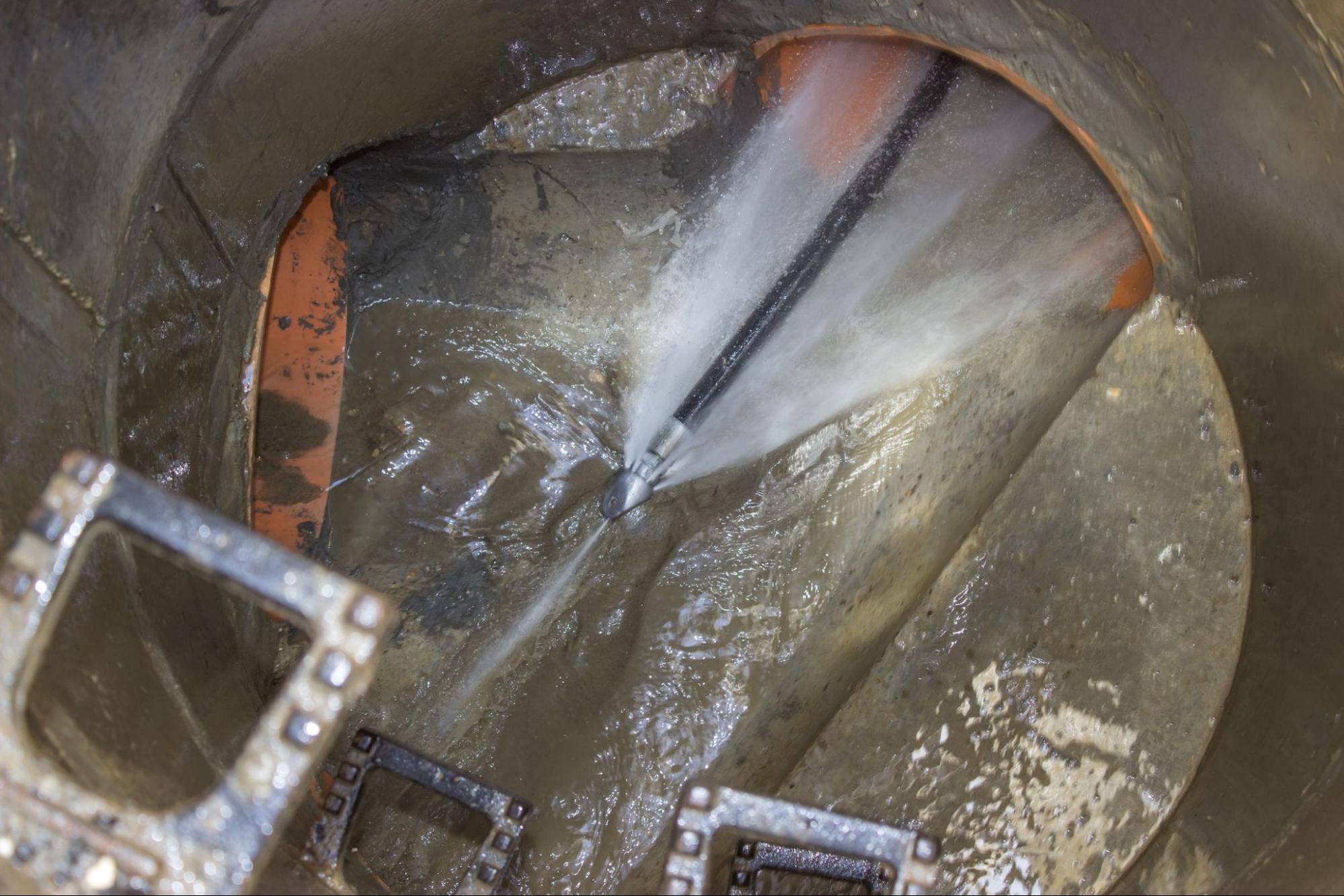 High-pressure water clearing buildup from a sewer pipe during hydro jet drain cleaning in Scottsdale, AZ.