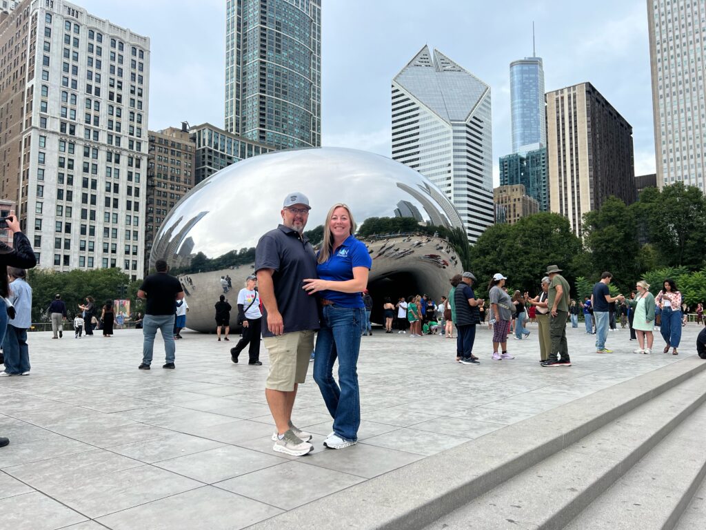 Owners of A&N Plumbing, a family-owned plumbing company, standing at Cloud Gate in Chicago.